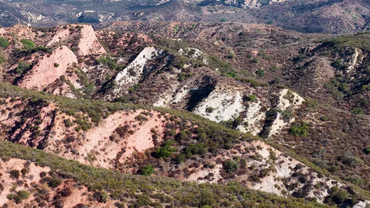 Drone flight over ridged, multicolored canyon formations in Black Star Canyon, California, revealing rugged and diverse terrain