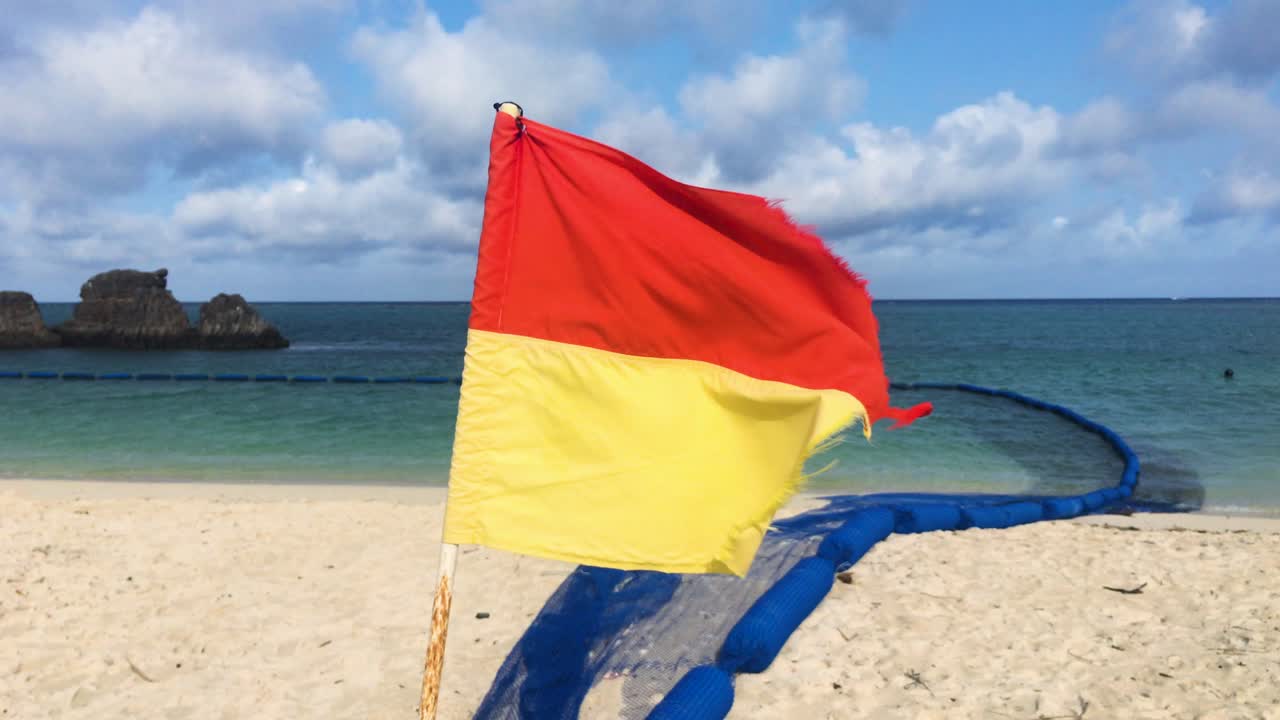 Bendera Penyelamat Pantai Merah dan Kuning yang Lusuh Berkibar Tertusuk Angin