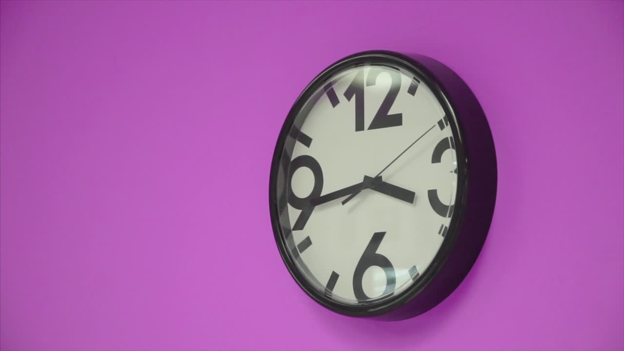 Black Round Wall Clock on Purple Background