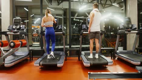 people exercising on treadmills in a gym