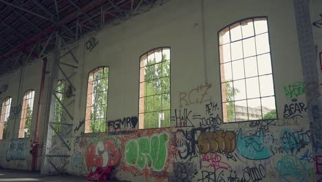 windows in abandoned industrial warehouse with metal structure and grafitti brick walls