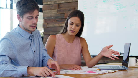 young man and woman in discussion in a creative office