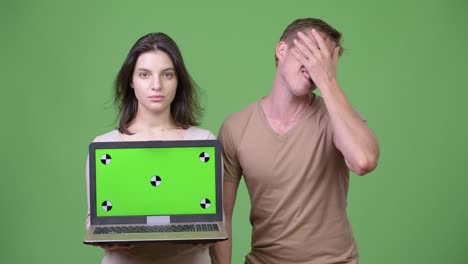 young couple showing laptop and getting bad news together