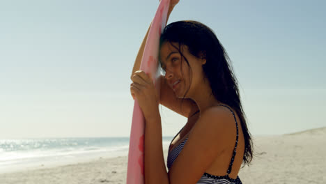 female surfer leaning on the surfboard on beach 4k 4k