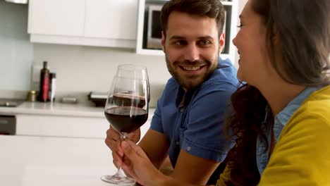 pareja brindando vasos de vino en la cocina