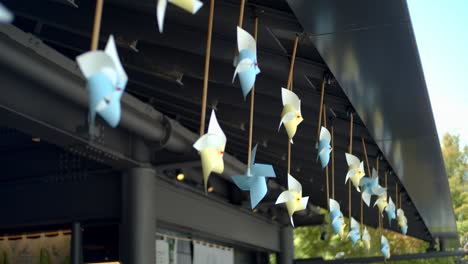 Viento-Que-Sopla-A-Través-De-Los-Molinos-De-Viento-De-Papel-Que-Cuelgan-Del-Costado-De-La-Azotea-En-Kyoto,-Japón-Iluminación-Suave-En-Verano-4k