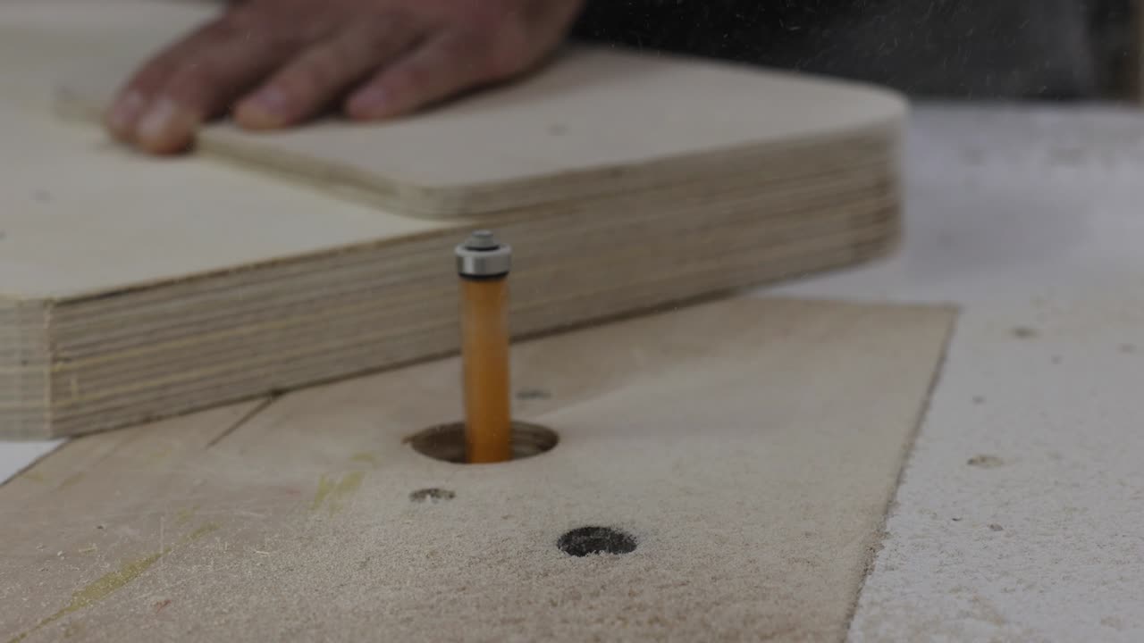 carpintero redondea las esquinas de una tabla de madera en una máquina de fresado en el taller