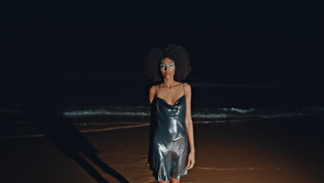woman in shimmering dress on a beach at night