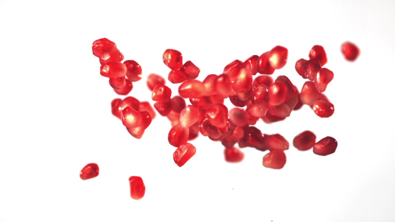 Pomegranate Seeds Falling and Floating in Slow Motion on White Background