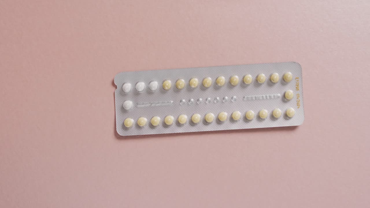 Video of close up of yellow tablets on pink background