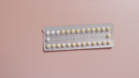 video de un primer plano de tabletas amarillas sobre un fondo rosa