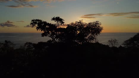 aerial drone forward movement capturing the mesmerizing uvita beach sunset in costa rica: an enchanting orange sun casting its glow upon the sea, vibrant natural beauty