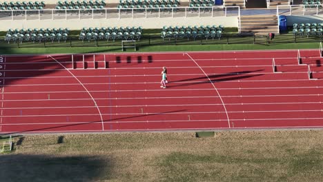 female athletes sprint on a sunlit track, navigating hurdles with precision. captured at gold coast, australia, showcasing dynamic motion
