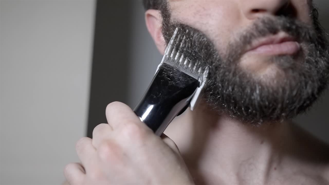 Electric Trimmer Cutting Thick Dark and Grey Beard Hair in Slow Motion
