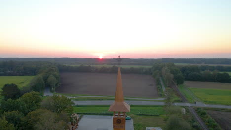 Aguja-De-La-Iglesia-En-Medio-Del-Campo-Verde-Al-Atardecer-En-Soegel,-Alemania