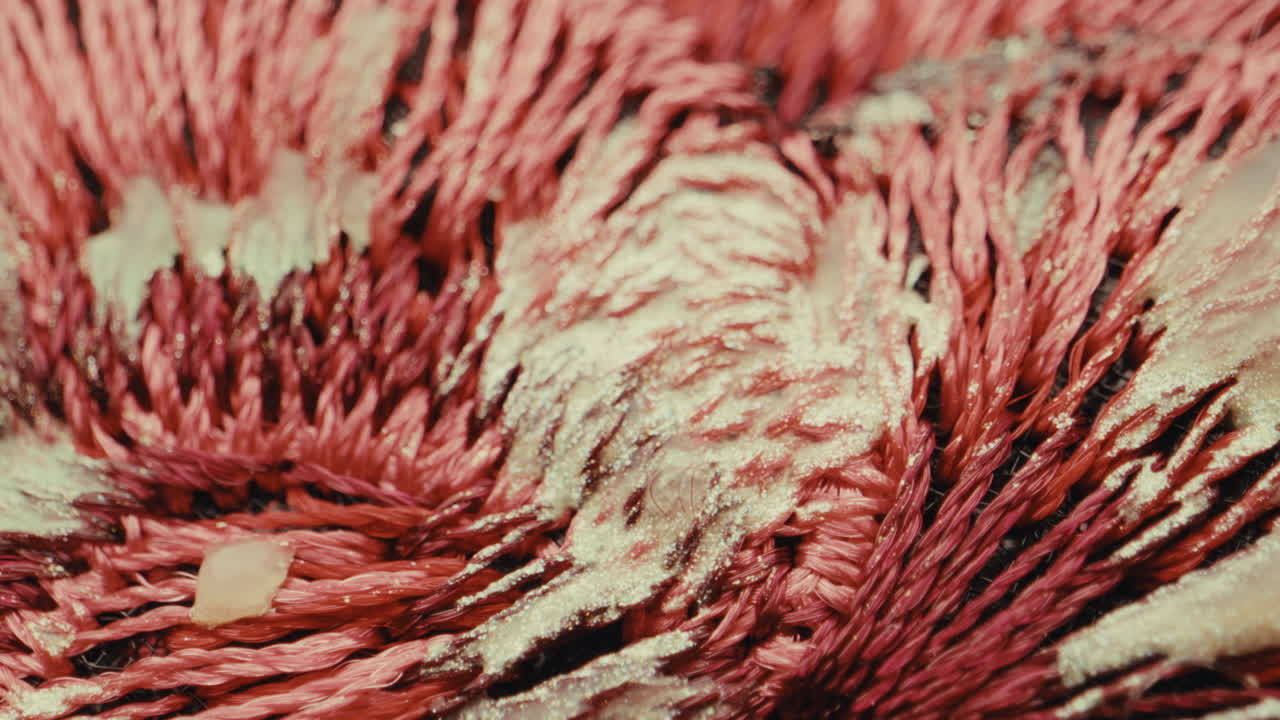 Close-up of Embroidered Fabric with Pink Threads and Gold Glitter