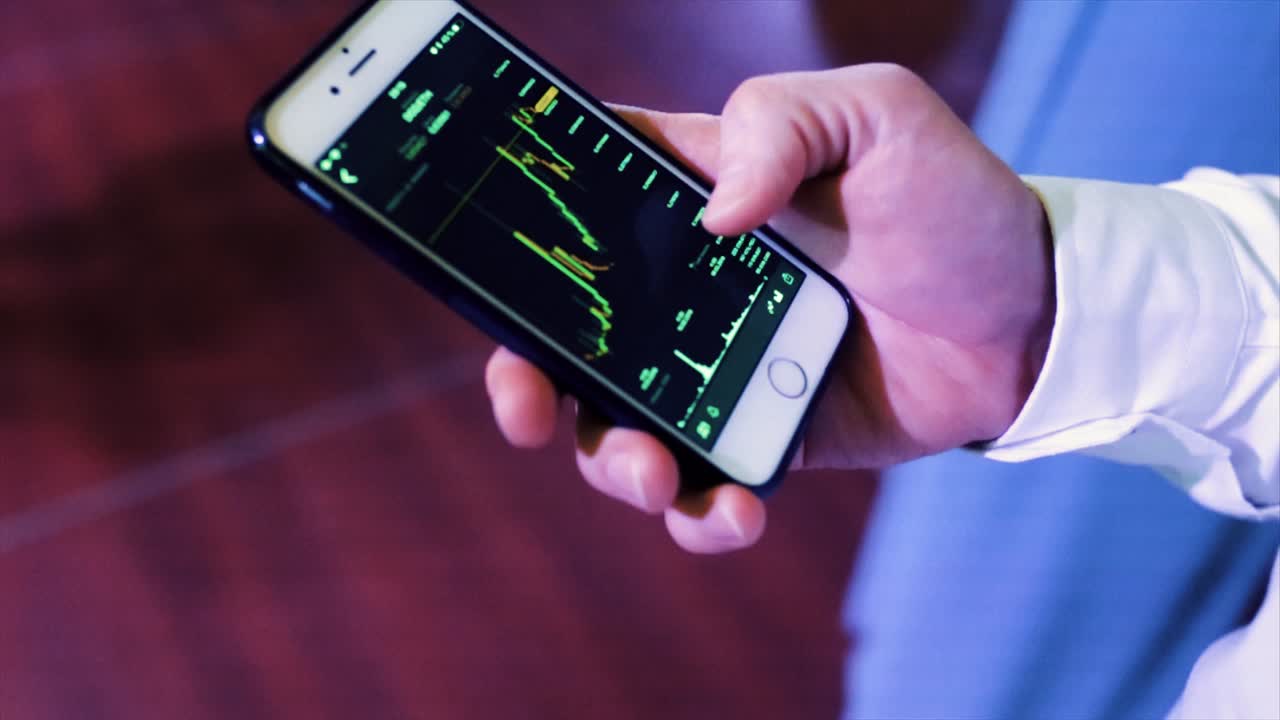 persona que mira el gráfico del mercado de valores en un teléfono inteligente