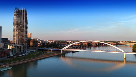 high-rise building near the arched bridge. footage above the danube with the view on the appolo bridge in bratislava, slovakia