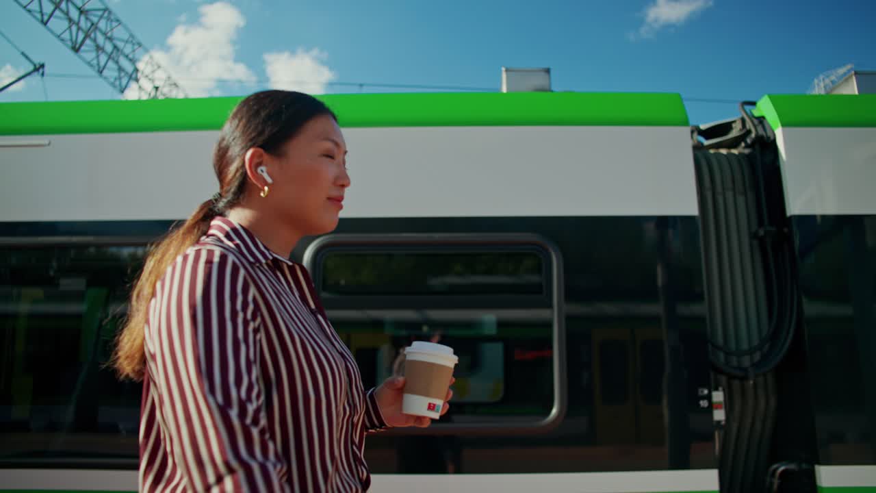 Donna su una banchina del treno con una tazza di caffè
