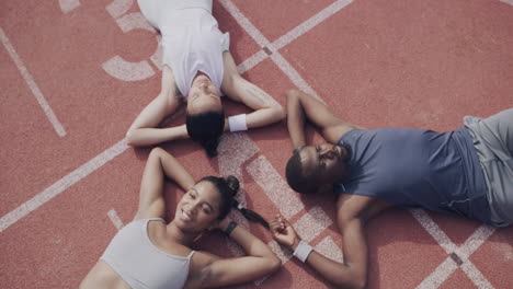 friends relaxing on a track after exercise