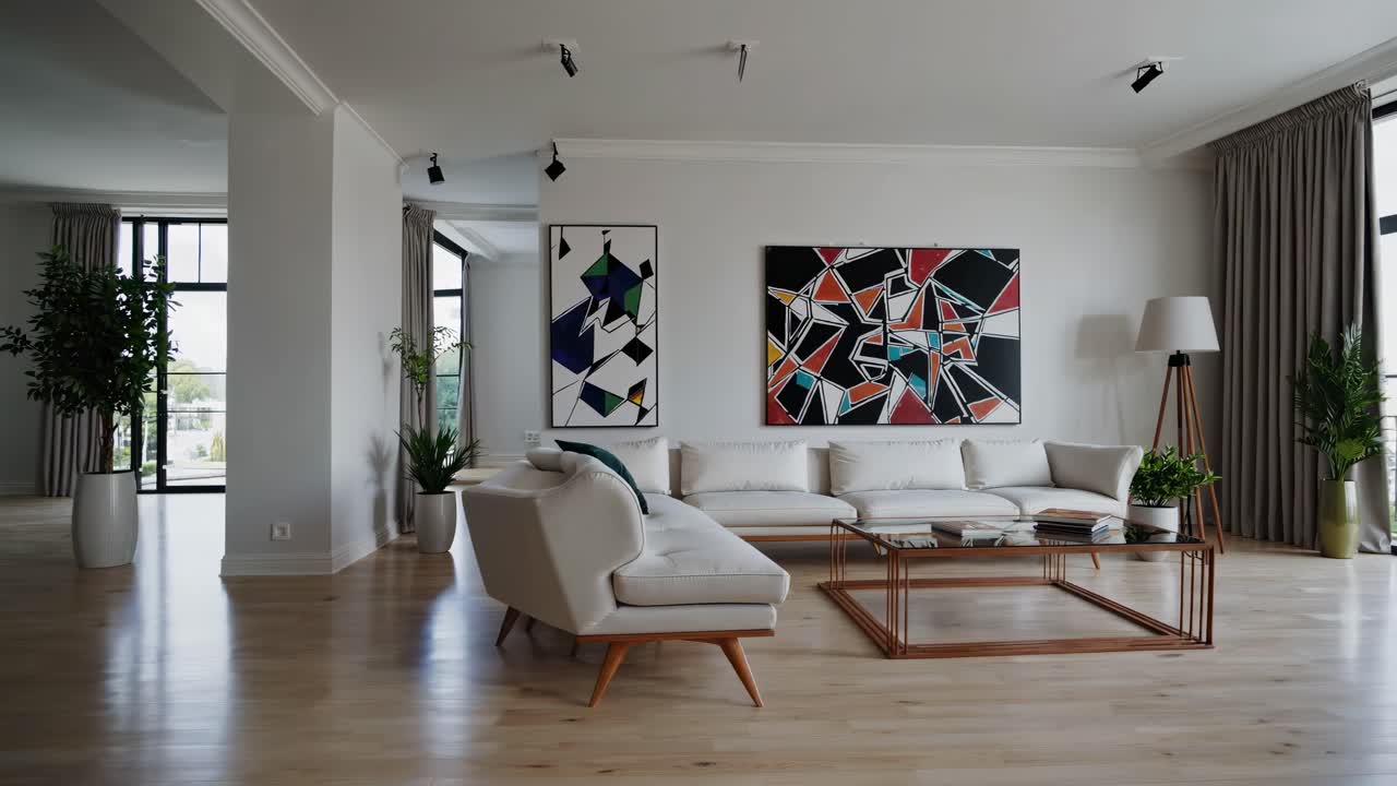 Wide-angle shot of a modern living room with abstract art, neutral tones, and natural light