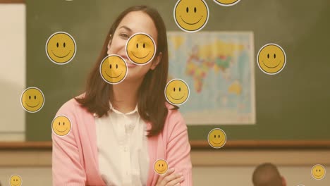 Composite-video-of-smiley-face-emojis-floating-against-caucasian-female-teacher-smiling-in-class