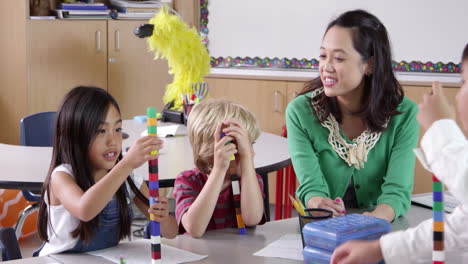 teacher sits with kids using blocks in class, shot on r3d