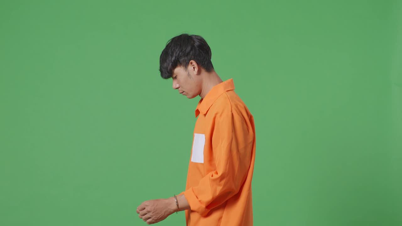 녹색 스크린 배경에서 손을 고 있는 아시아 남성 죄수