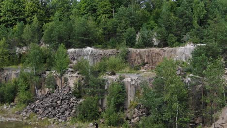 aerial view of rocky quarry surrounded by trees tracking left