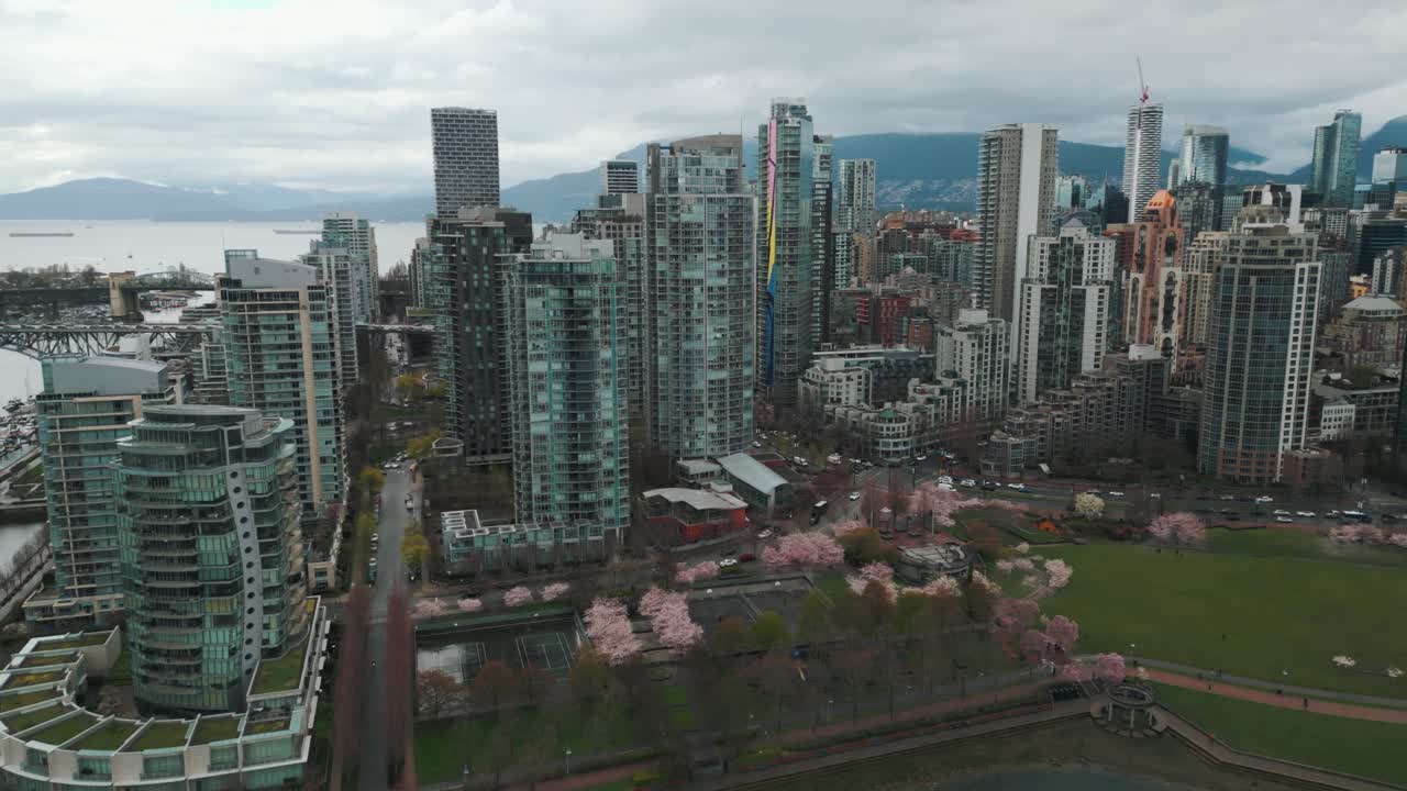 fotografía aérea alrededor de la ciudad de vancouver marinaside y el parque david lam con flores de cerezo y el horizonte en un día nublado, columbia británica, canadá
