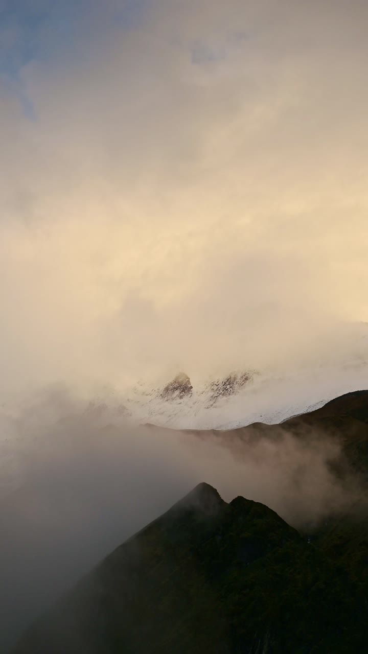 Vertical Sunset Mountains Background with Copy Space for Text, Vertical Video of Dramatic Rugged Mountain Scenery in Yellow Clouds for Social Media Instagram Reels and Tiktok
