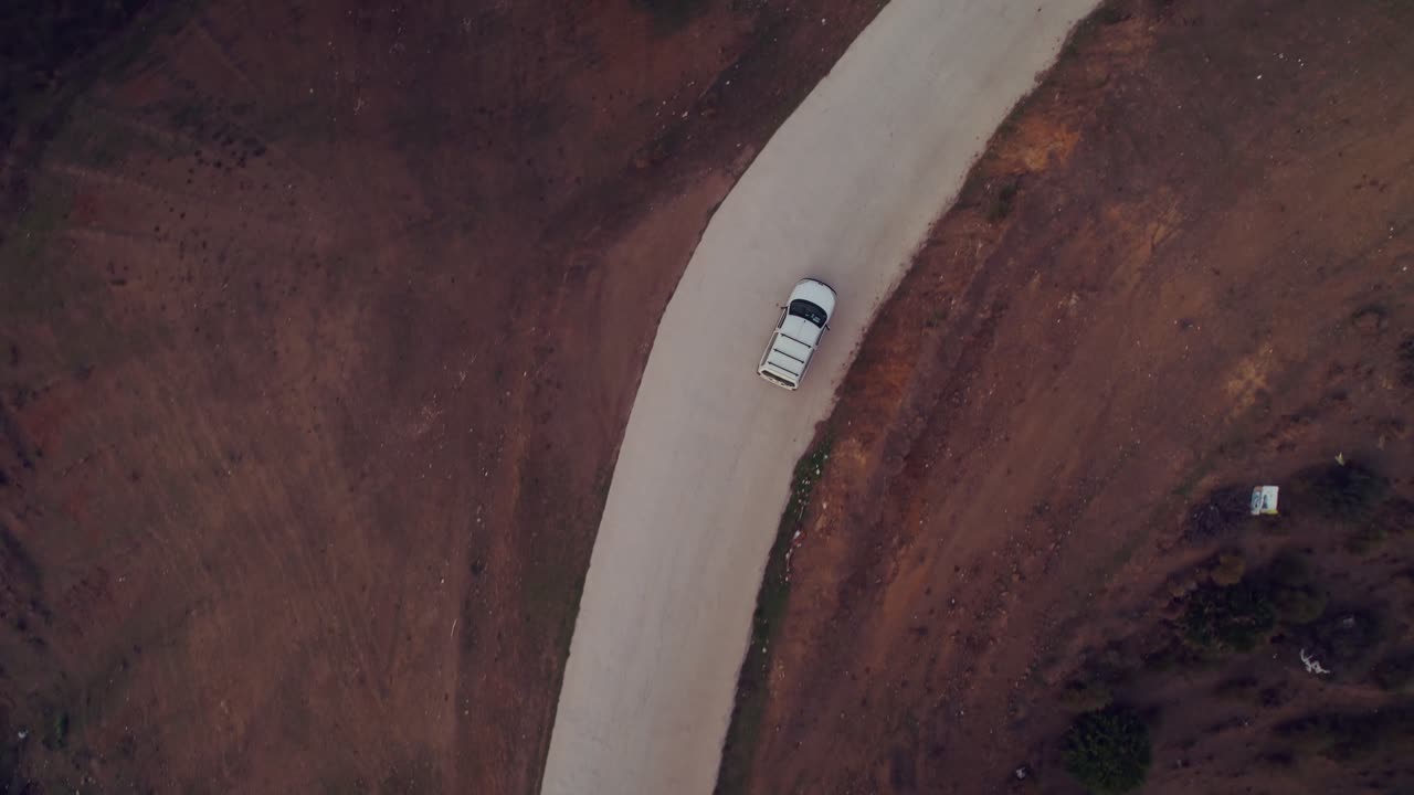 Vista aerea che segue un'auto su una strada di campagna.
