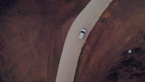 Vista-Aérea-Siguiendo-Un-Coche-En-La-Carretera-Del-Campo