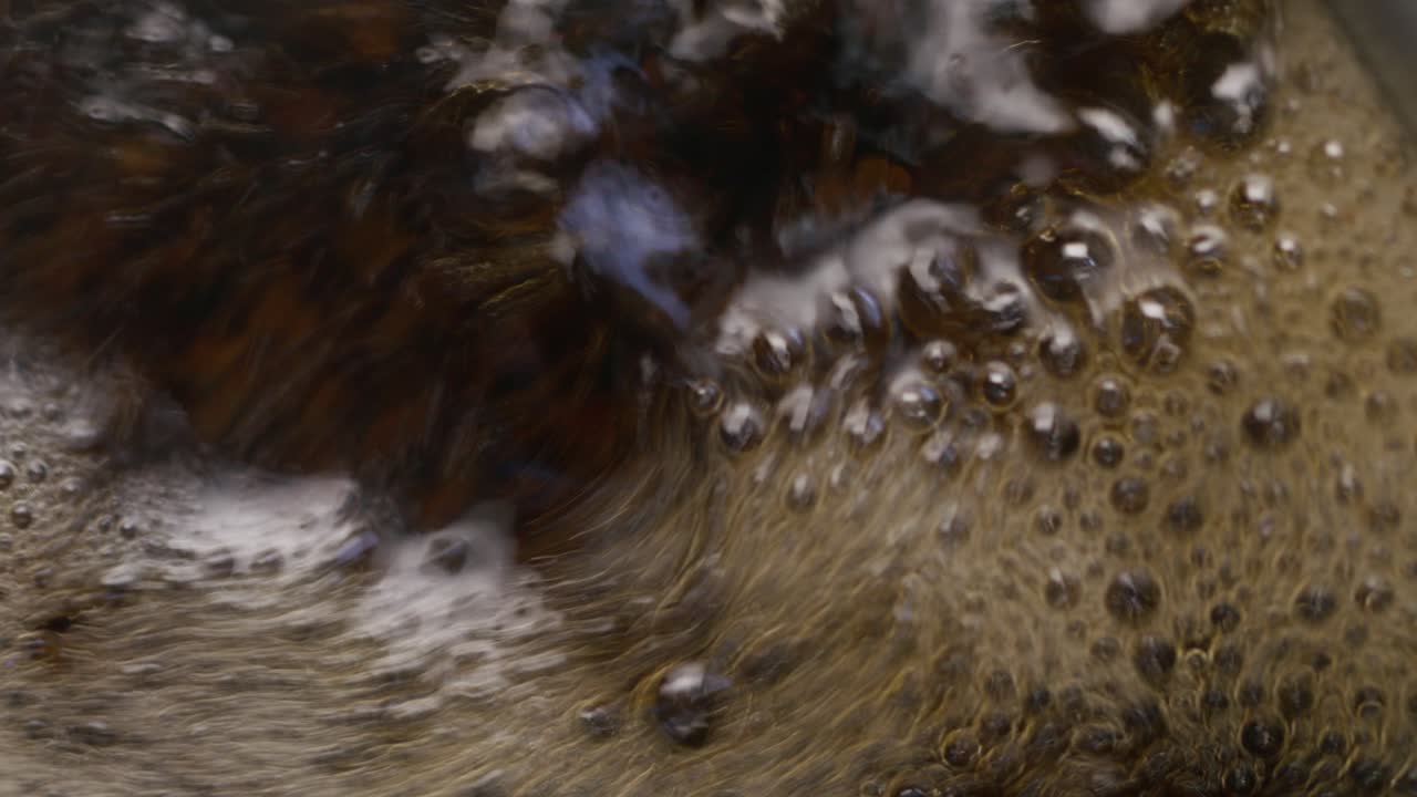 A detailed close-up of bubbling tea with foam