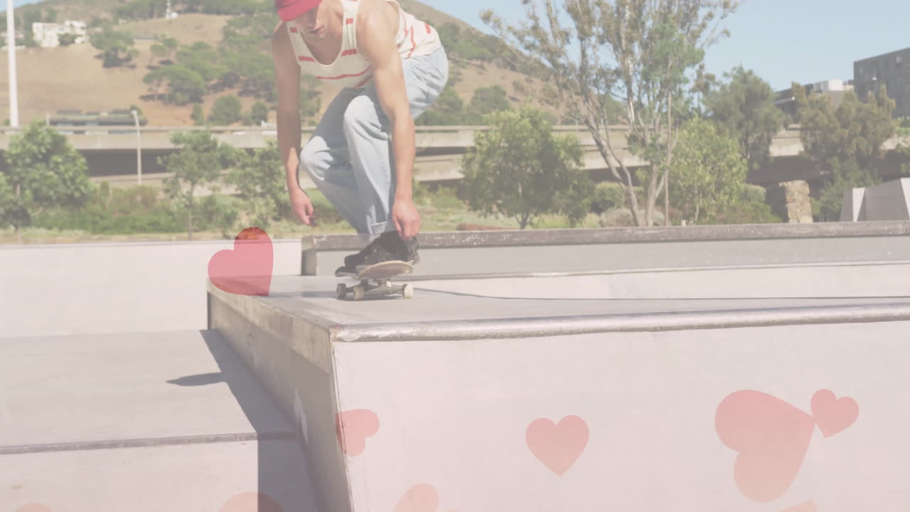 male skateboarder crouching on ramp at skatepark, showing pink heart graphics for marketing theme