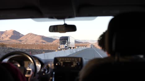 driving along a road in the mojave desert on a highway divided because of construction - view from the back seat with front seat occupants visible