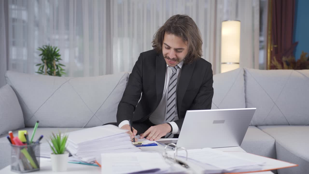 un hombre de negocios feliz y alegre llega a casa y comienza a trabajar.