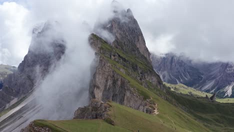 stunning cloud covered scenic mountain at puez odle national park, dolomites, italy - drone tilt up flight