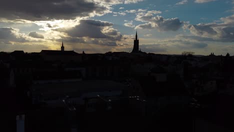 an aerial view of a city caslav in czechia backlit by a sunset