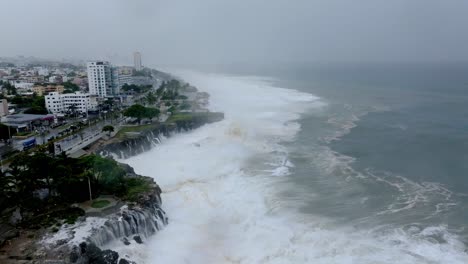 aerial view of giant cyclone waves crashing and flooding the seafront of the city