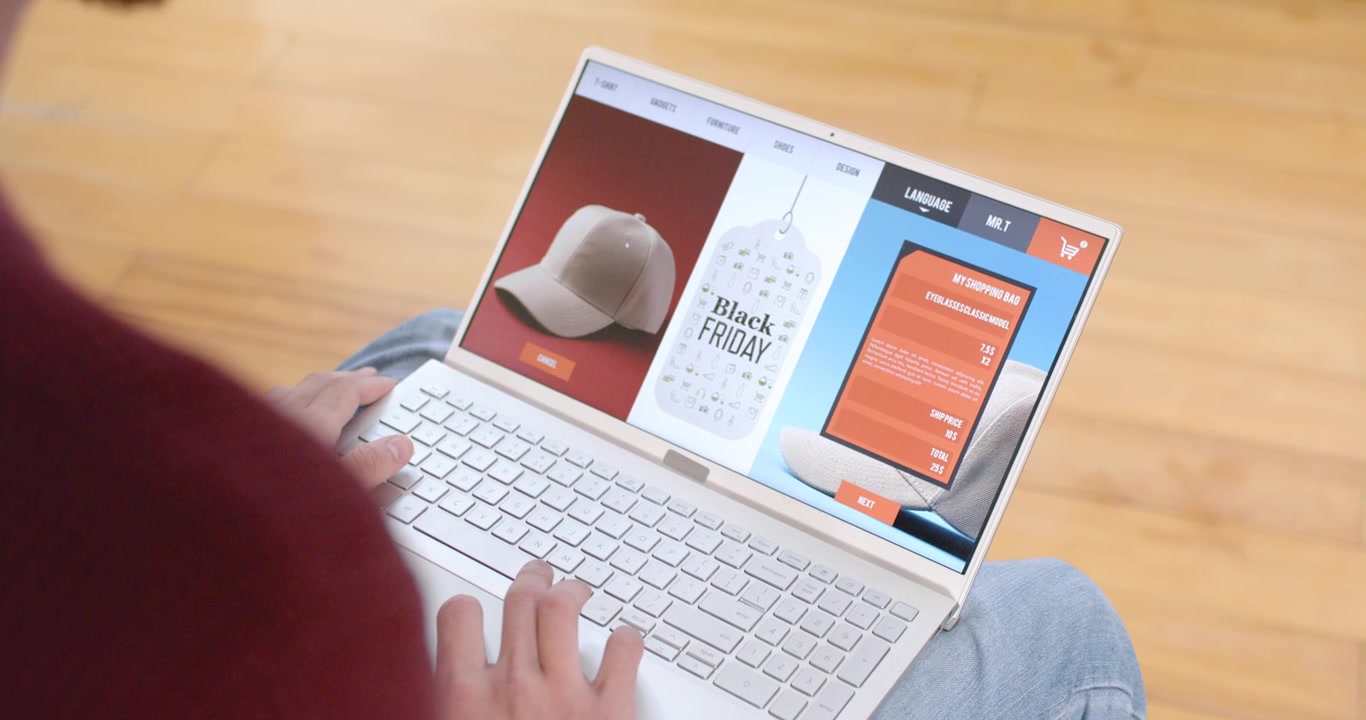 Seeing Black Friday tag on laptop screen, man browsing 3-col page, comparing options using trackpad