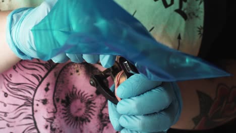 tatuador preparando la máquina de tatuar de manera profesional