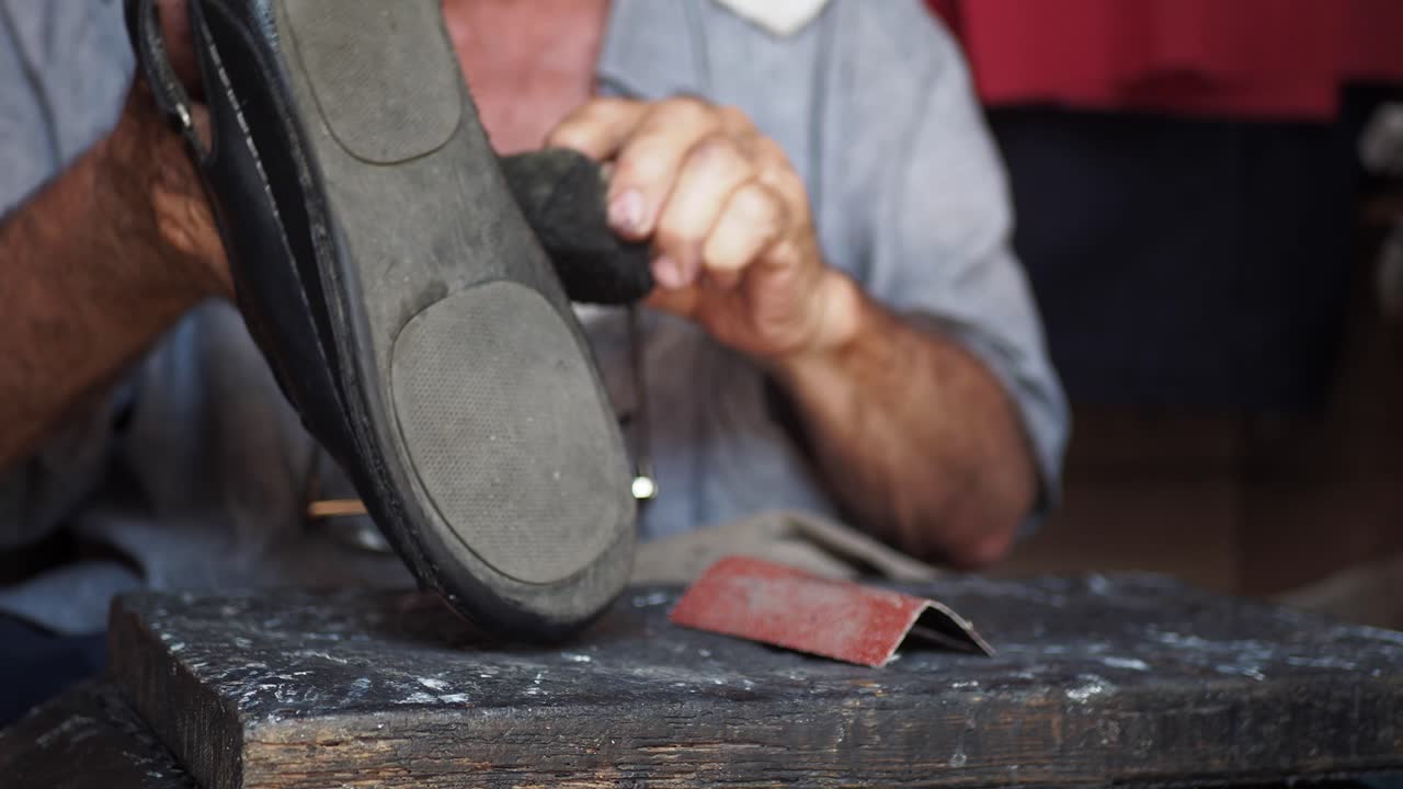un hombre reparando un zapato en su taller