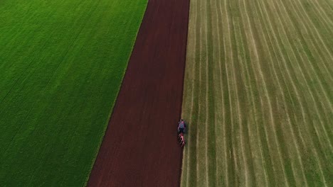 Agroculture-field-ploughing-with-four-furrow-reversible-plough-aerial-wide-view