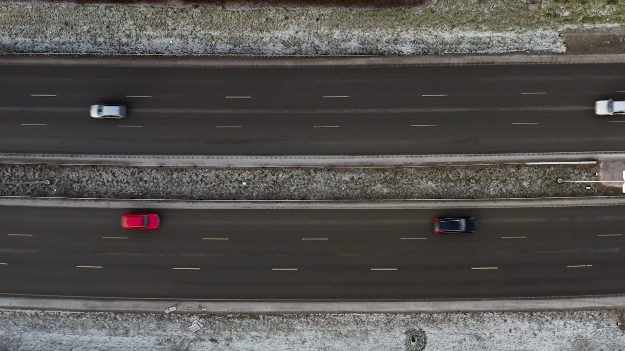 Aerial, top down, drone shot, rising above cars on parallel streets, some frost on the ground, in Helsinki city, on a overcast, winter day, in Finland