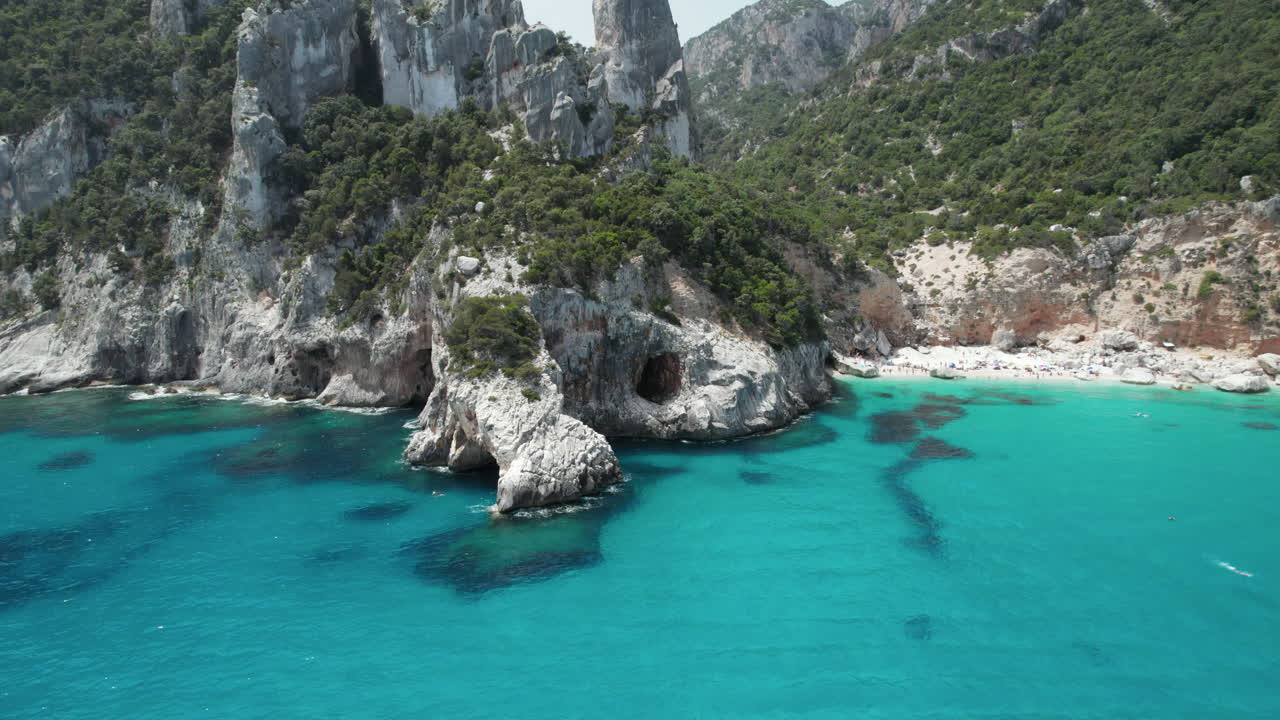 Aerial drone video of tropical paradise turquoise beach and sea cliffs in the mediterranean, Cala Goloritzè, Sardinia, Italy