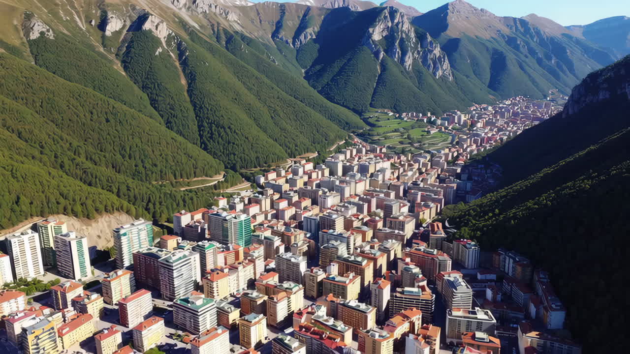 Aerial view of a city nestled in a valley surrounded by mountains