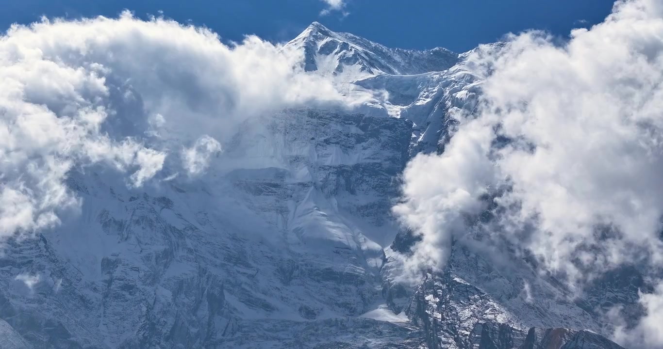 Annapurna Circuit, Manang, Nepal, timelapse-opptak fra luften av skyer som feier over den snødekte siden av Annapurna II fjelltoppen, og avslører den mytiske Yeti-ansikt-fjellformasjonen.