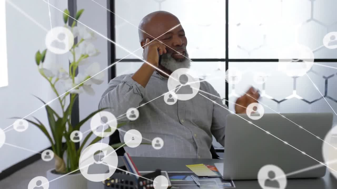 Animation of network of profile icons over african american man talking on smartphone at office