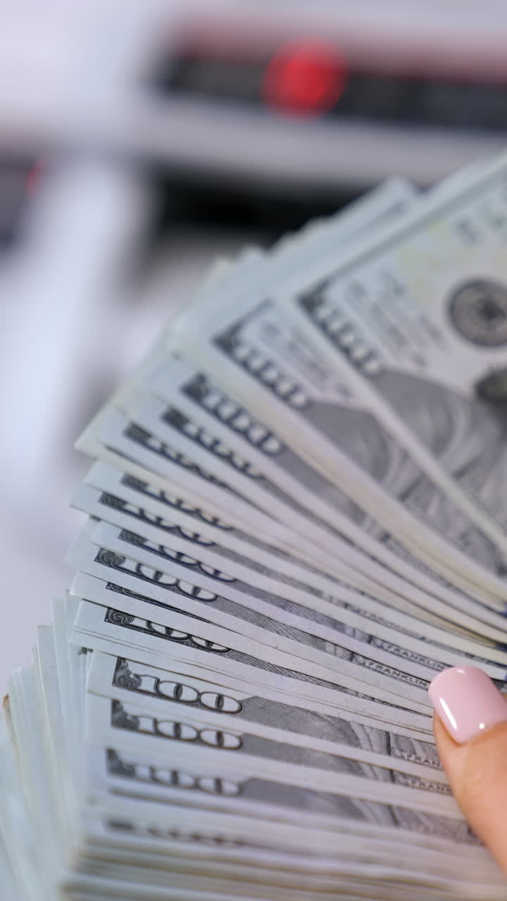 business, finance, saving, banking and people concept - close up of woman hands counting us dollar money Vertical video